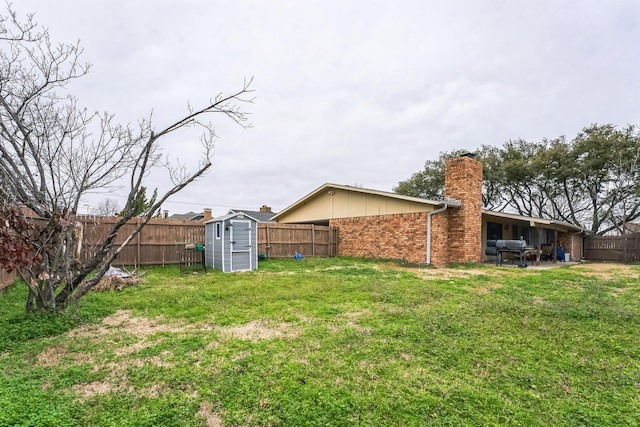 view of yard with a storage unit, an outbuilding, and a fenced backyard