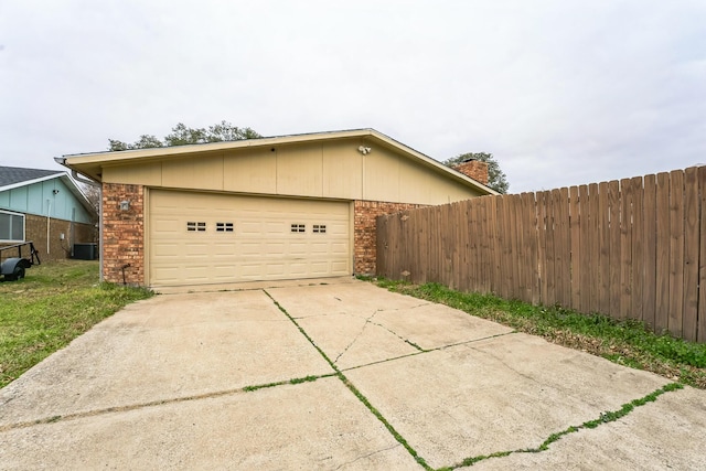 view of side of property with fence, brick siding, and driveway