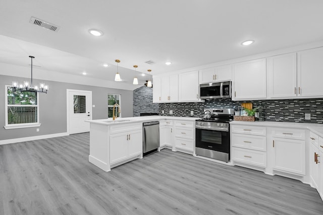 17127 Port O Call St, Crosby, TX 77532 - kitchen featuring visible vents, a sink, stainless steel appliances, light wood-style floors, and a peninsula