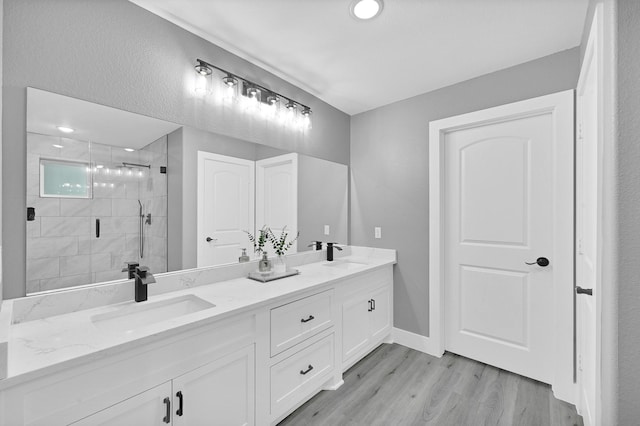17127 Port O Call St, Crosby, TX 77532 - bathroom featuring double vanity, wood finished floors, a stall shower, and a sink