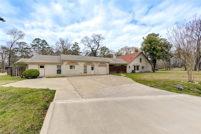 single story home featuring an attached garage, driveway, and a front lawn