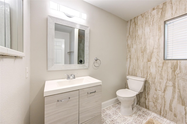 bathroom with vanity, toilet, baseboards, and tile patterned flooring