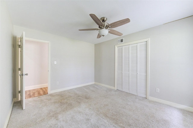 unfurnished bedroom featuring a closet, visible vents, ceiling fan, and carpet