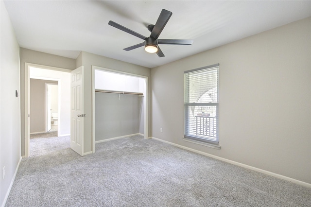 unfurnished bedroom featuring a closet, baseboards, light colored carpet, and a ceiling fan