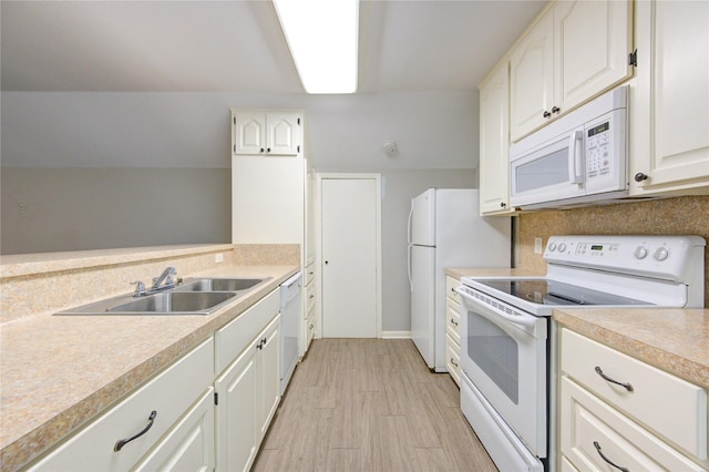 kitchen with white appliances, a sink, light countertops, white cabinets, and backsplash