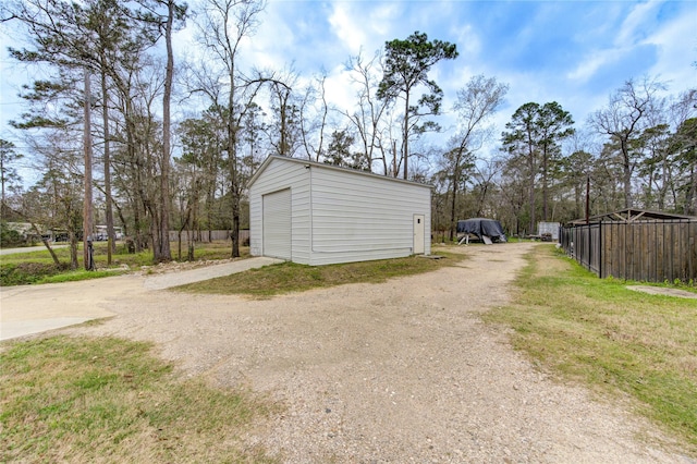 detached garage featuring dirt driveway