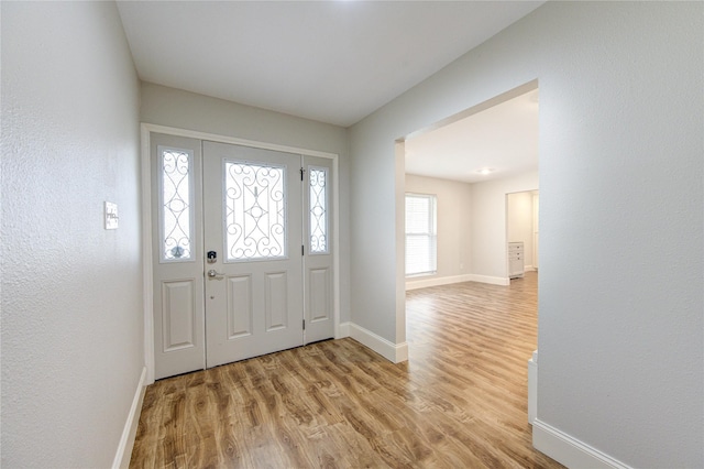 entryway featuring baseboards and light wood finished floors