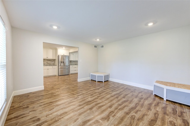 empty room with recessed lighting, light wood-style flooring, and baseboards