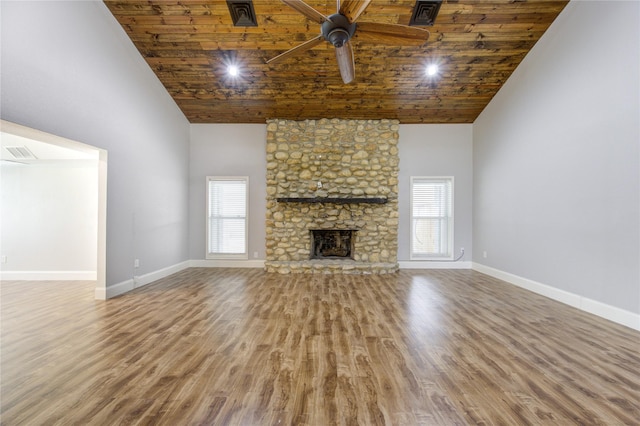 unfurnished living room featuring plenty of natural light, wood finished floors, and high vaulted ceiling