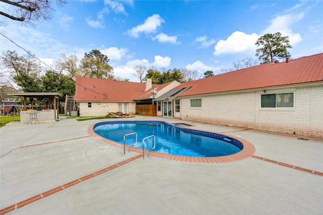 outdoor pool featuring outdoor dry bar and a patio