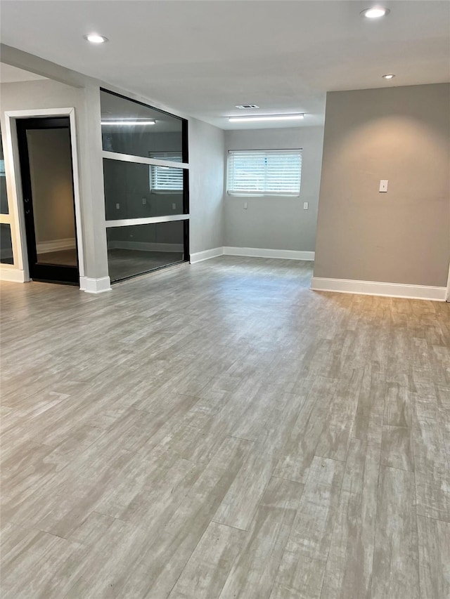 unfurnished living room with recessed lighting, baseboards, and wood finished floors