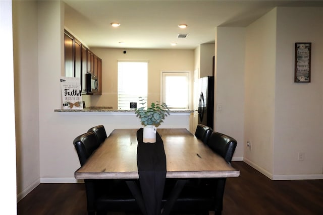 dining room featuring wood finished floors, baseboards, and visible vents