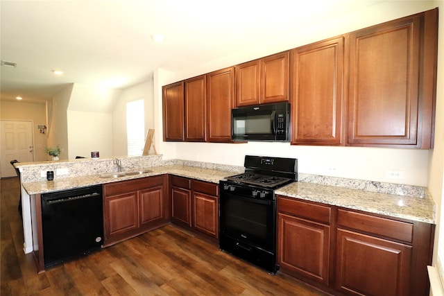 kitchen with black appliances, a sink, a peninsula, light stone countertops, and dark wood-style flooring