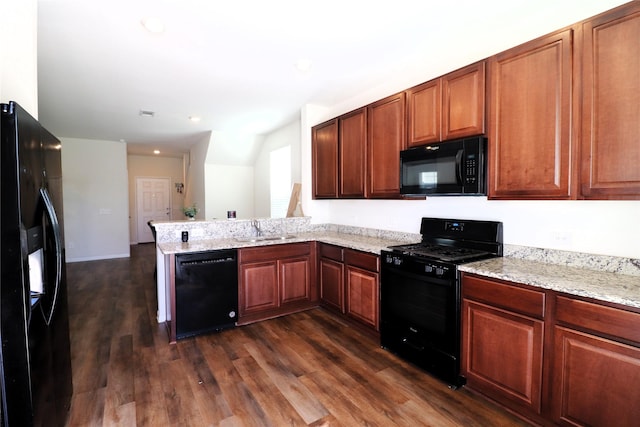 kitchen with light stone counters, dark wood finished floors, a peninsula, a sink, and black appliances