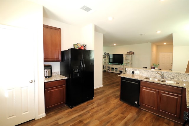 kitchen with black appliances, dark wood-style floors, visible vents, and a sink