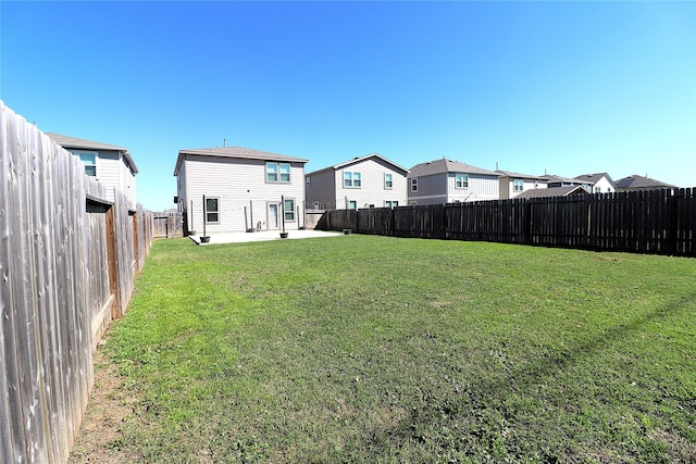 view of yard featuring a patio area, a residential view, and a fenced backyard