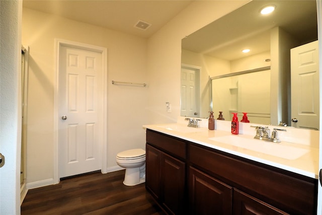 full bathroom featuring visible vents, a shower stall, wood finished floors, and a sink