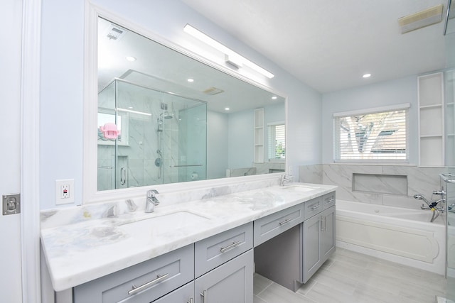 full bathroom with a marble finish shower, visible vents, double vanity, a bath, and a sink