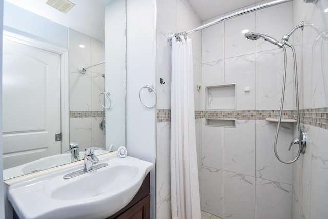 bathroom featuring visible vents, vanity, and a shower stall