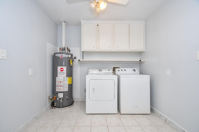 washroom featuring baseboards, light tile patterned flooring, cabinet space, gas water heater, and washer and clothes dryer