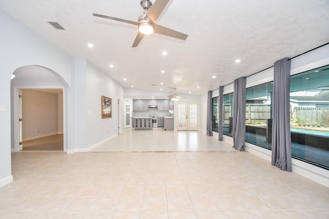 unfurnished living room featuring visible vents, a ceiling fan, recessed lighting, arched walkways, and baseboards