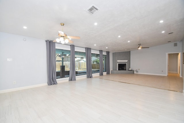 unfurnished living room featuring baseboards, visible vents, recessed lighting, ceiling fan, and a large fireplace