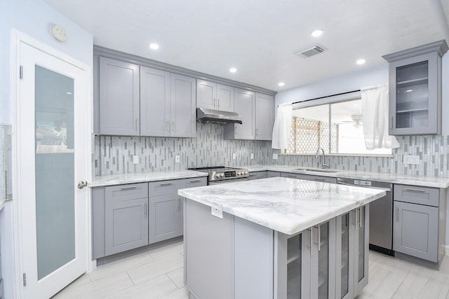 kitchen featuring under cabinet range hood, visible vents, gray cabinetry, and a sink