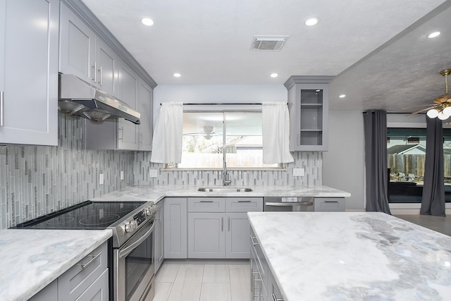 kitchen featuring under cabinet range hood, visible vents, appliances with stainless steel finishes, and gray cabinetry