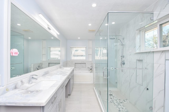 full bathroom featuring a sink, a marble finish shower, and a wealth of natural light