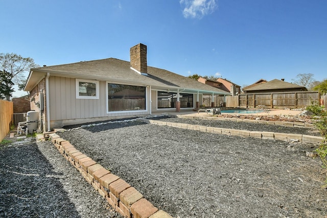 back of house featuring a fenced in pool, a fenced backyard, a chimney, and a patio area