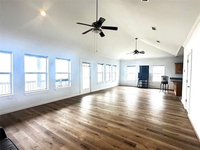 unfurnished living room featuring baseboards, dark wood-style flooring, crown molding, and vaulted ceiling