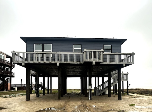 exterior space with driveway, a carport, a deck, and stairs