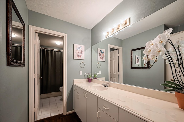 bathroom featuring vanity, toilet, and a textured ceiling