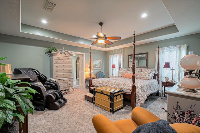 bedroom with visible vents, multiple windows, carpet, and a tray ceiling