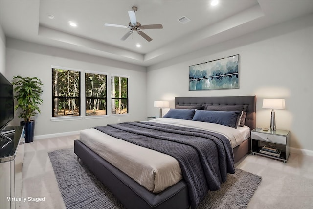 bedroom featuring a tray ceiling, visible vents, and baseboards