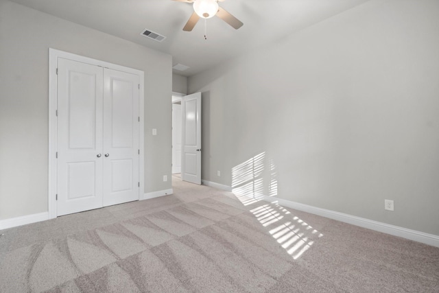 unfurnished bedroom with carpet flooring, baseboards, visible vents, and a closet