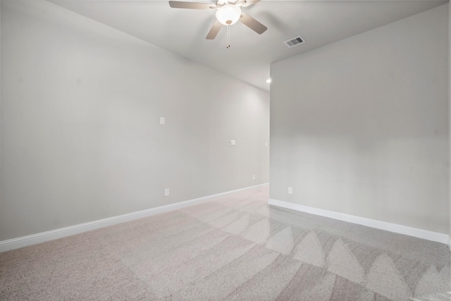 empty room featuring visible vents, light carpet, baseboards, and ceiling fan