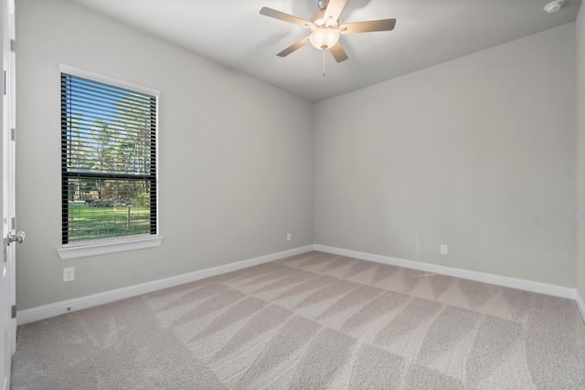 carpeted spare room with baseboards and ceiling fan