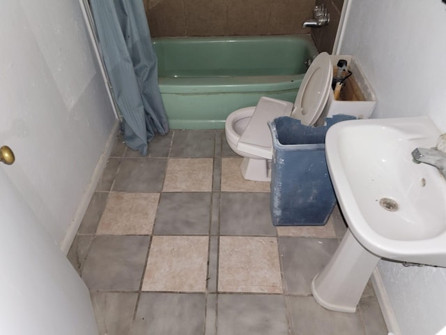 bathroom featuring tile patterned floors, toilet, and a sink