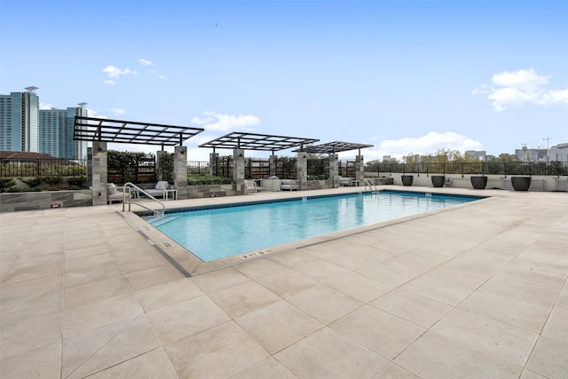 pool with a pergola, a patio, and fence