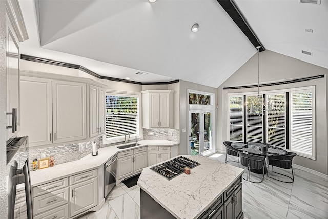 kitchen featuring a kitchen island, lofted ceiling with beams, a sink, stainless steel appliances, and tasteful backsplash