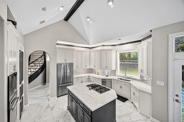 kitchen featuring decorative backsplash, marble finish floor, stainless steel appliances, and a sink