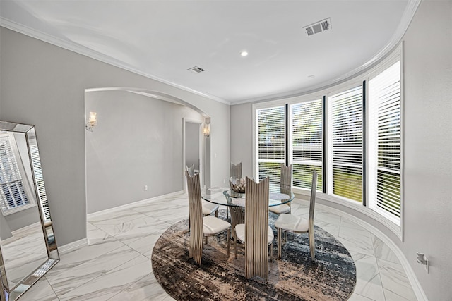 dining area featuring arched walkways, visible vents, baseboards, and ornamental molding