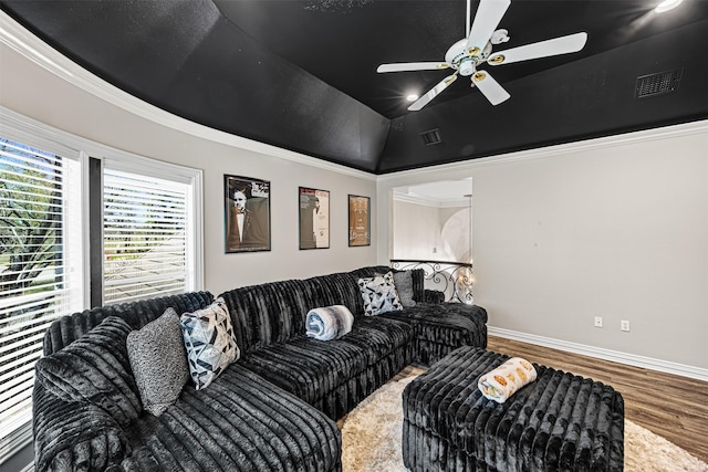 living area with visible vents, wood finished floors, crown molding, baseboards, and vaulted ceiling