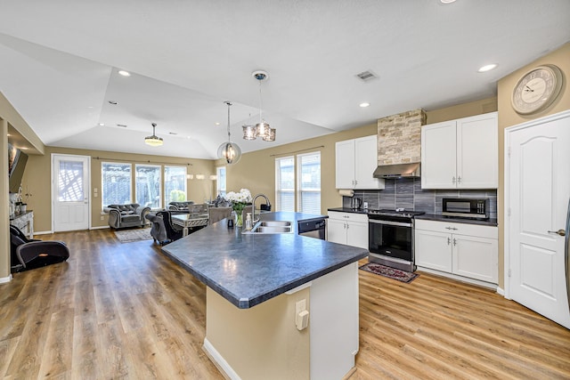 kitchen with dark countertops, visible vents, black microwave, stainless steel stove, and a sink