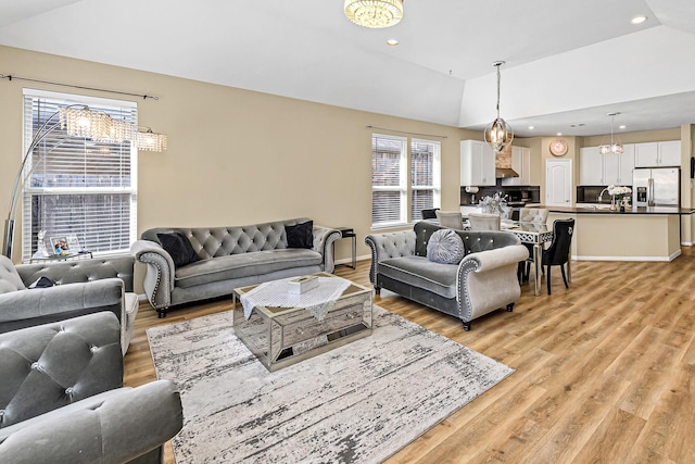 living area featuring lofted ceiling, recessed lighting, baseboards, and light wood finished floors