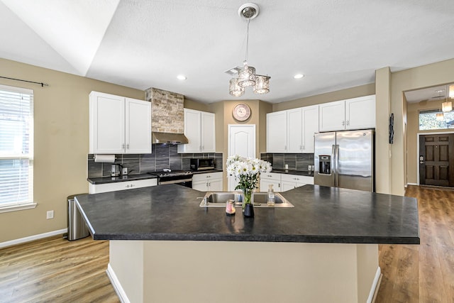 kitchen featuring dark countertops, under cabinet range hood, decorative backsplash, appliances with stainless steel finishes, and white cabinets