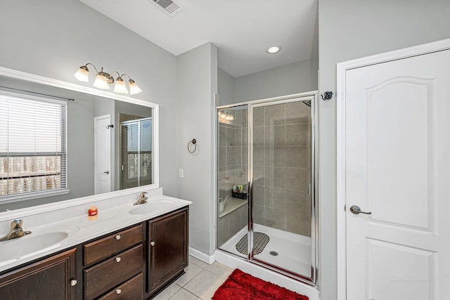 full bath featuring tile patterned flooring, a shower stall, and a sink