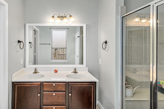 bathroom with a sink, a stall shower, and double vanity