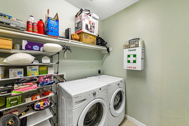 washroom featuring laundry area, baseboards, and washing machine and clothes dryer